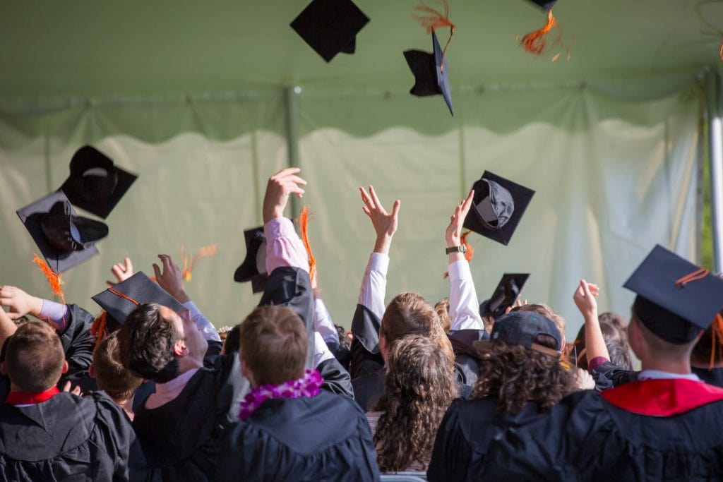 graduates throwing hats in air
